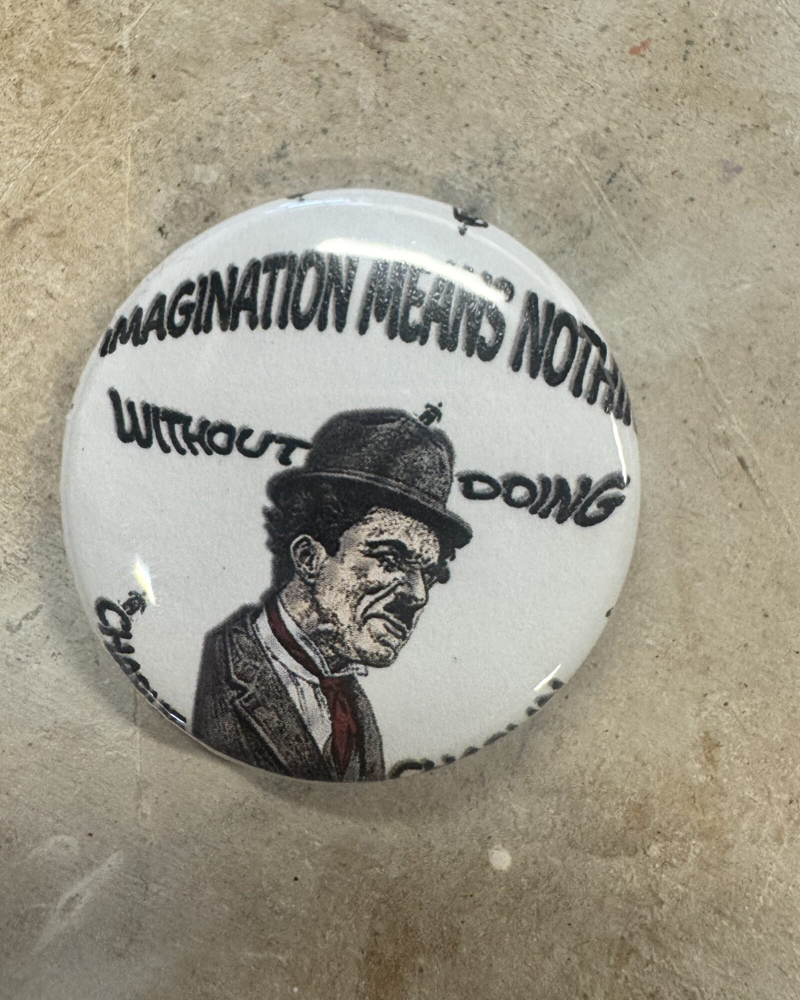 Pinback button with Charlie Chaplin portrait and text around the rim